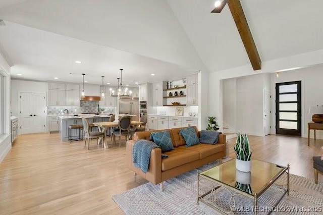 living area with high vaulted ceiling, beam ceiling, light wood-style flooring, recessed lighting, and a chandelier