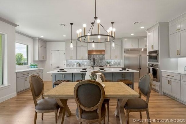 dining space featuring light wood-style flooring, recessed lighting, baseboards, and ornamental molding