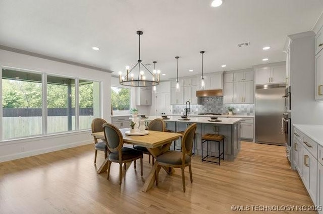 dining room featuring visible vents, baseboards, an inviting chandelier, light wood-style flooring, and recessed lighting