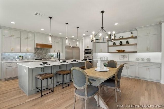 dining space with recessed lighting, visible vents, a notable chandelier, and light wood finished floors