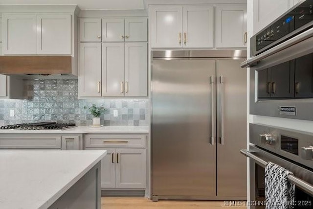 kitchen featuring light countertops, white cabinets, backsplash, and stainless steel appliances