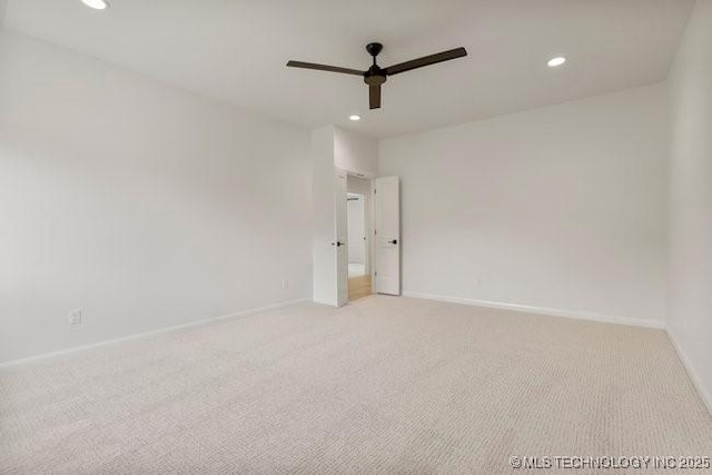 empty room featuring recessed lighting, baseboards, and light carpet