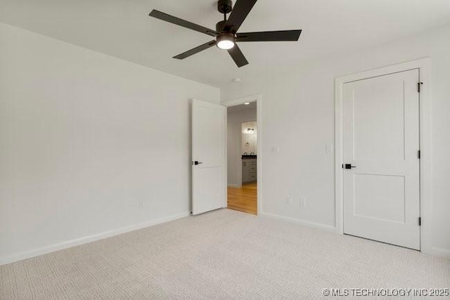 unfurnished bedroom with baseboards, light carpet, and ceiling fan