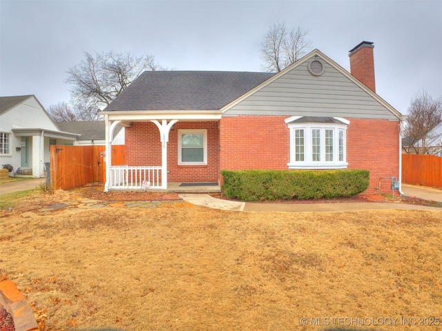2538 E 17th Pl, Tulsa, OK 74104 - view of front facade with brick siding, a porch, a chimney, and fence