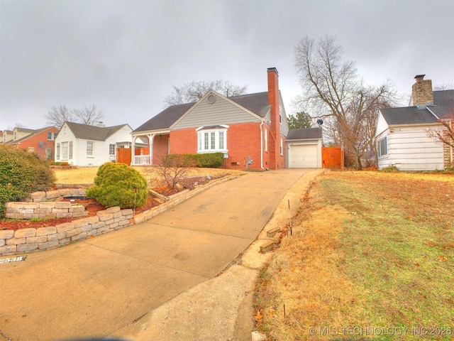 view of front of property with a chimney, concrete driveway, an outdoor structure, a garage, and brick siding