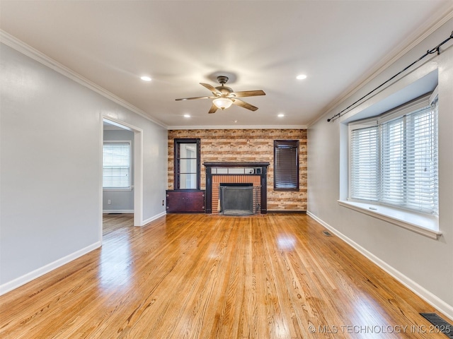 unfurnished living room featuring a brick fireplace, crown molding, ceiling fan, baseboards, and light wood-type flooring