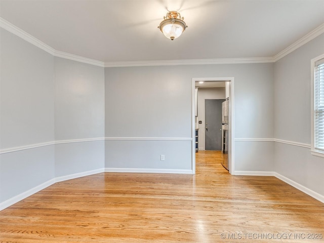 spare room featuring crown molding, baseboards, and light wood-type flooring