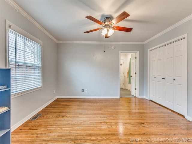 unfurnished bedroom featuring crown molding, light wood-style floors, and visible vents