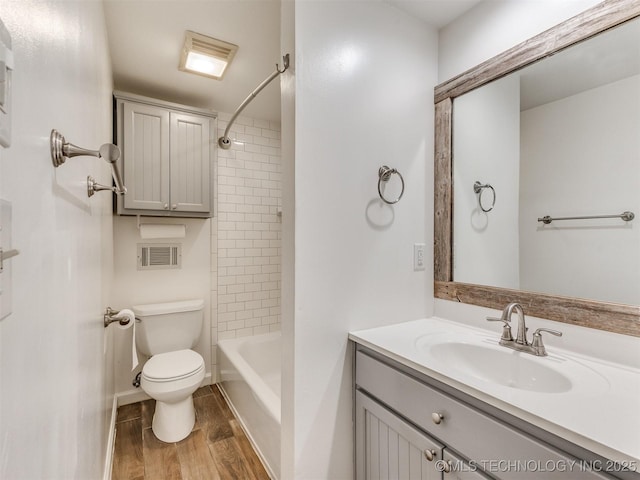 full bathroom with visible vents, toilet, shower / bathing tub combination, wood finished floors, and vanity