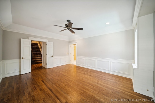 empty room with stairway, a ceiling fan, wood finished floors, and crown molding