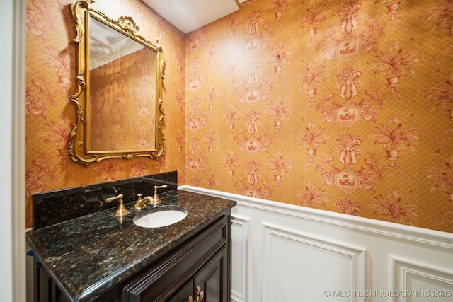 219 E 28th St, Tulsa, OK 74114 - bathroom featuring wallpapered walls, wainscoting, vanity, and a decorative wall
