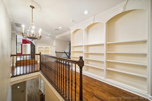 corridor with wood finished floors, visible vents, recessed lighting, crown molding, and a notable chandelier