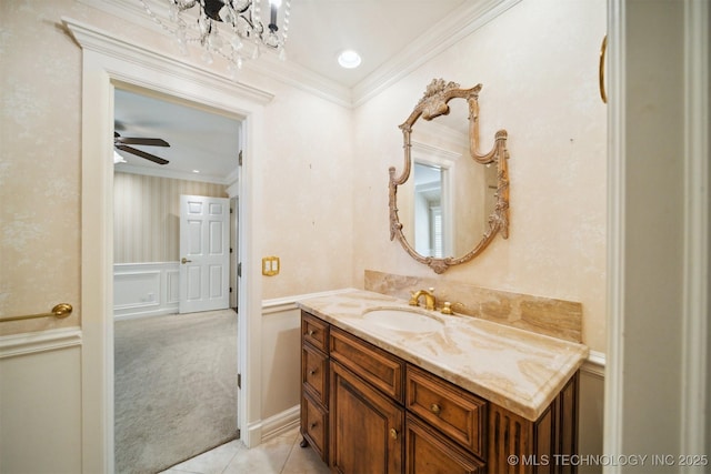 219 E 28th St, Tulsa, OK 74114 - bathroom with a decorative wall, vanity, crown molding, a wainscoted wall, and tile patterned flooring