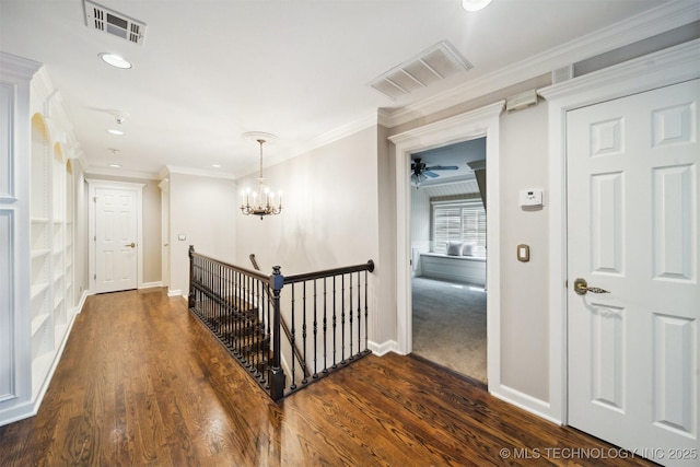 hall featuring visible vents, an upstairs landing, dark wood-type flooring, and ornamental molding