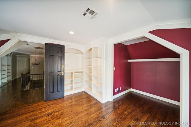 additional living space with built in features, wood finished floors, visible vents, and baseboards