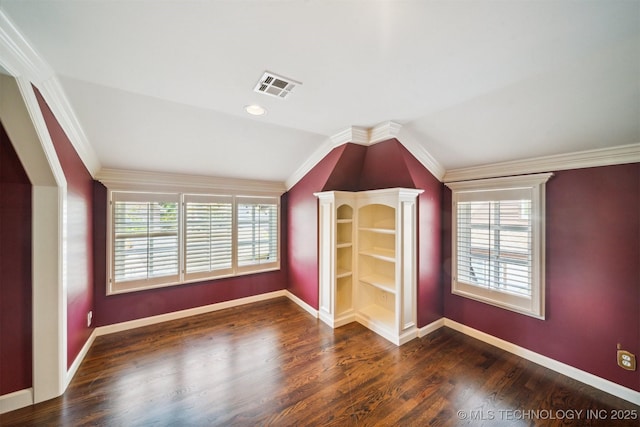 unfurnished room featuring visible vents, wood finished floors, baseboards, and vaulted ceiling