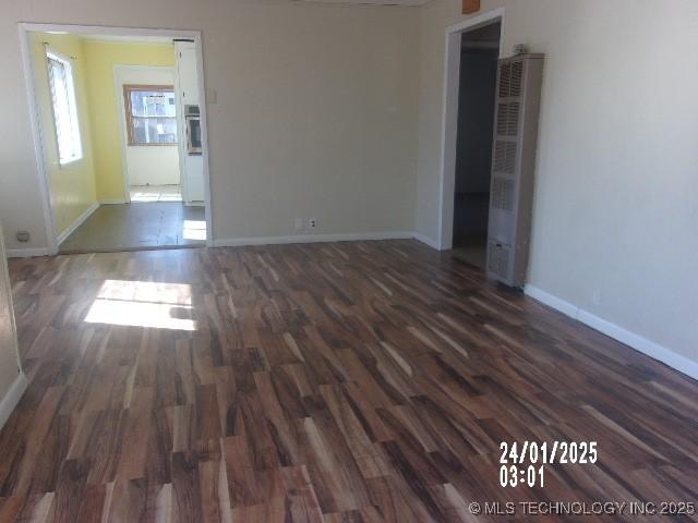 empty room featuring baseboards and wood finished floors