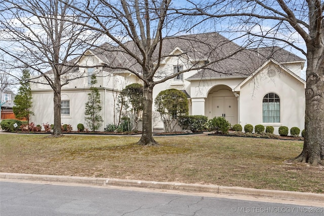 view of front of home with stucco siding and a front yard