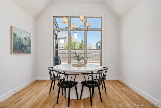 dining space featuring lofted ceiling, light wood-type flooring, and baseboards