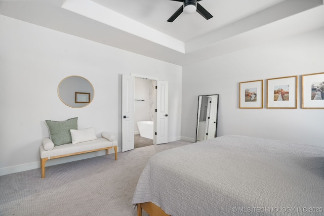 bedroom featuring baseboards, carpet, a tray ceiling, and a ceiling fan