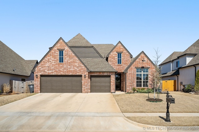 view of front of property featuring fence, brick siding, driveway, and a shingled roof