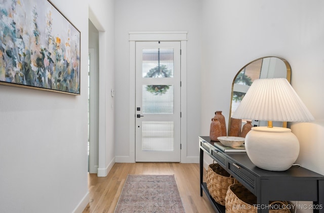 foyer entrance with baseboards and wood finished floors