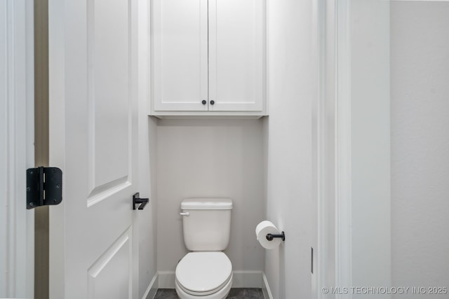 bathroom with baseboards and toilet