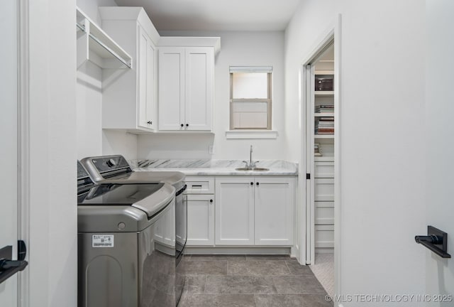 laundry area with a sink, cabinet space, and washing machine and clothes dryer