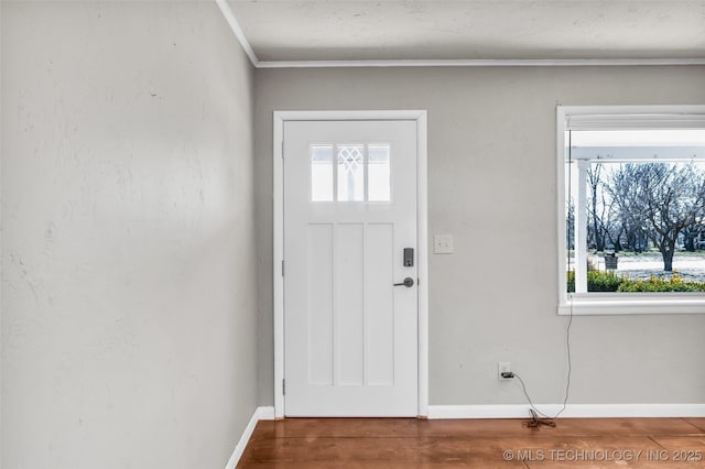 entrance foyer with crown molding, baseboards, and wood finished floors