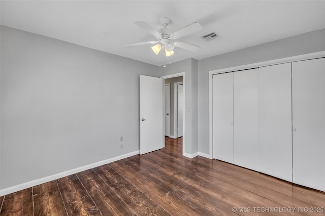 unfurnished bedroom with a ceiling fan, wood finished floors, baseboards, visible vents, and a closet