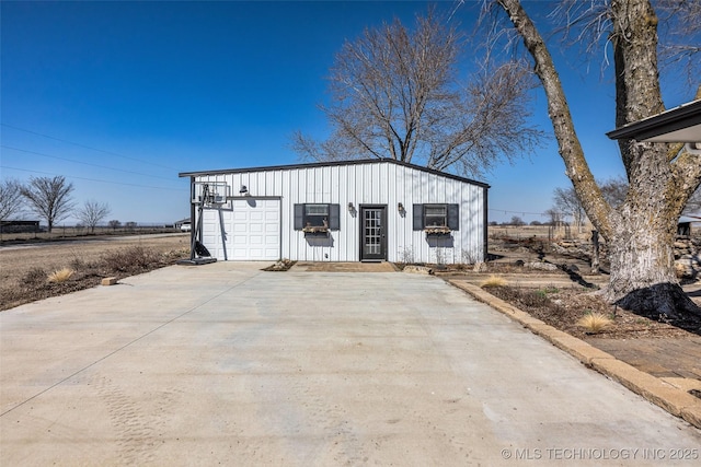 view of outdoor structure featuring a garage and concrete driveway