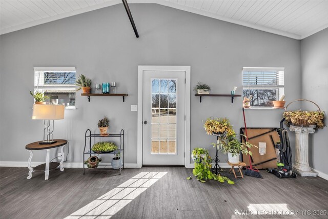 entryway featuring lofted ceiling, wood finished floors, baseboards, and ornamental molding