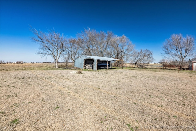 view of yard featuring an outbuilding and a rural view