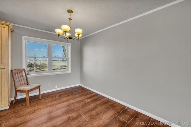 unfurnished room with dark wood finished floors, a notable chandelier, crown molding, and baseboards