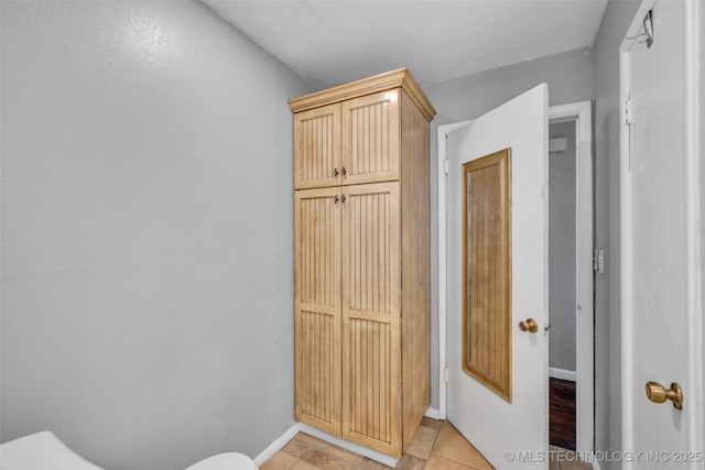 bathroom featuring tile patterned floors, toilet, and baseboards