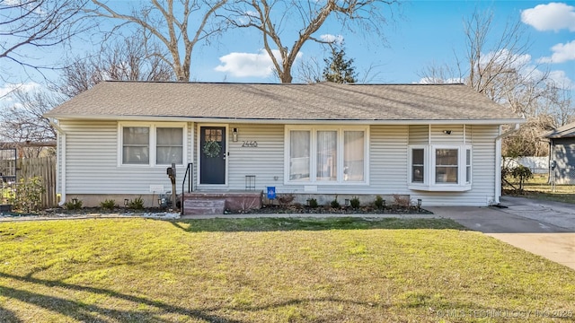 ranch-style house with roof with shingles, a front yard, and fence