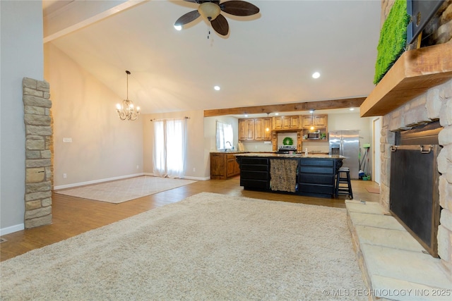 living area featuring beamed ceiling, ceiling fan with notable chandelier, light wood-type flooring, and baseboards