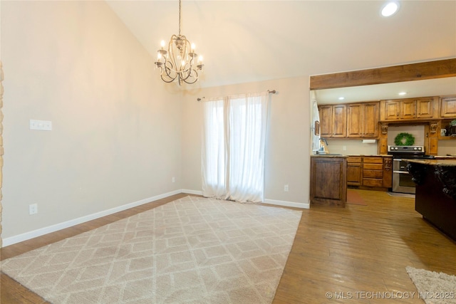 kitchen with brown cabinets, baseboards, light wood-style floors, and range with two ovens