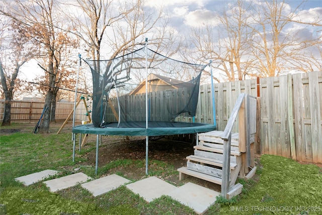 view of yard featuring a trampoline and a fenced backyard