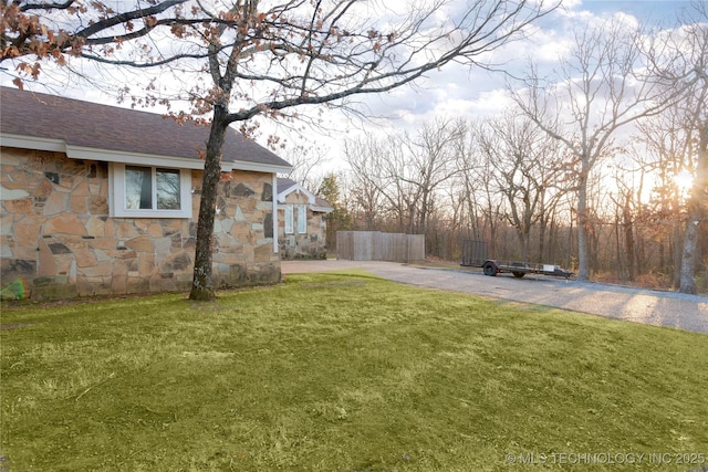 view of yard with driveway and fence