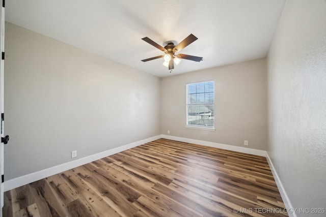 spare room featuring wood finished floors, baseboards, and ceiling fan