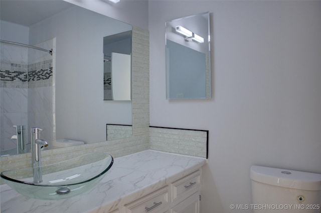 bathroom with a shower, toilet, and vanity