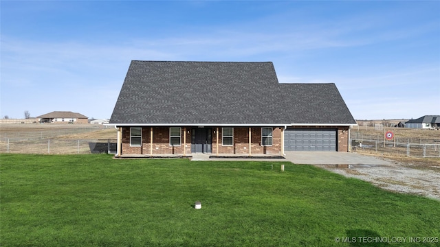 view of front facade with a porch, fence, concrete driveway, a front yard, and brick siding