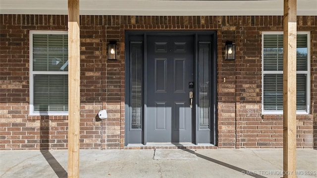 view of exterior entry with brick siding