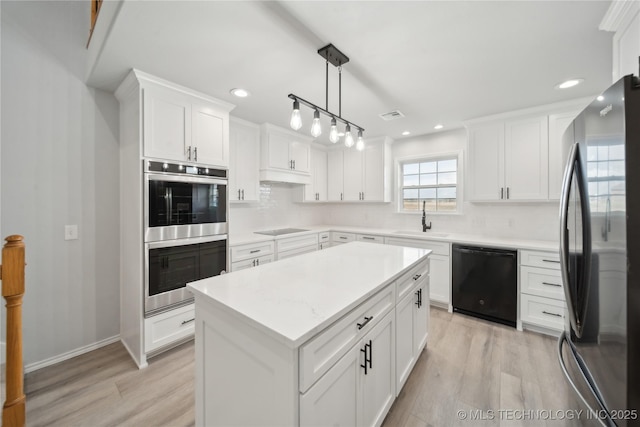 kitchen featuring white cabinetry, black appliances, light wood-style flooring, and a sink