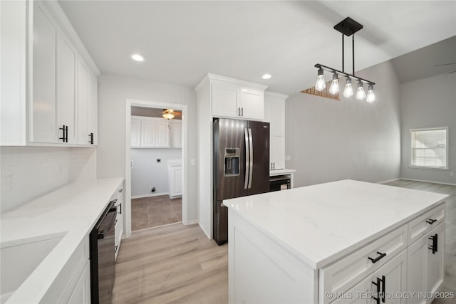 kitchen featuring fridge with ice dispenser, a sink, backsplash, black dishwasher, and white cabinets