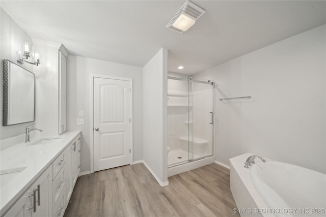 bathroom with a shower stall, wood finished floors, visible vents, and a sink