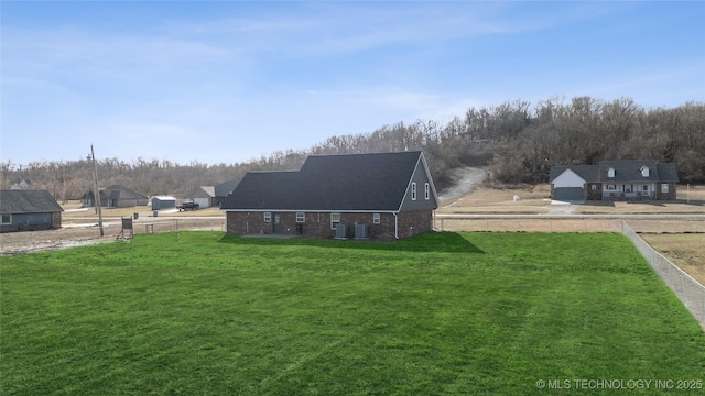 back of property with a yard and brick siding