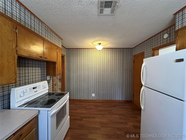 kitchen featuring visible vents, dark wood-type flooring, white appliances, brown cabinetry, and wallpapered walls