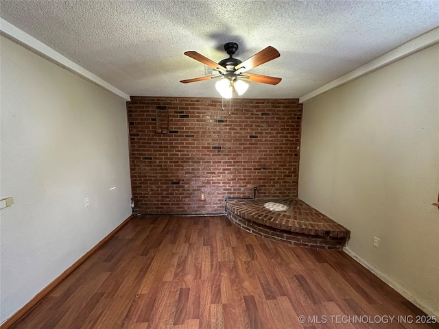 empty room featuring ceiling fan, baseboards, a textured ceiling, and wood finished floors